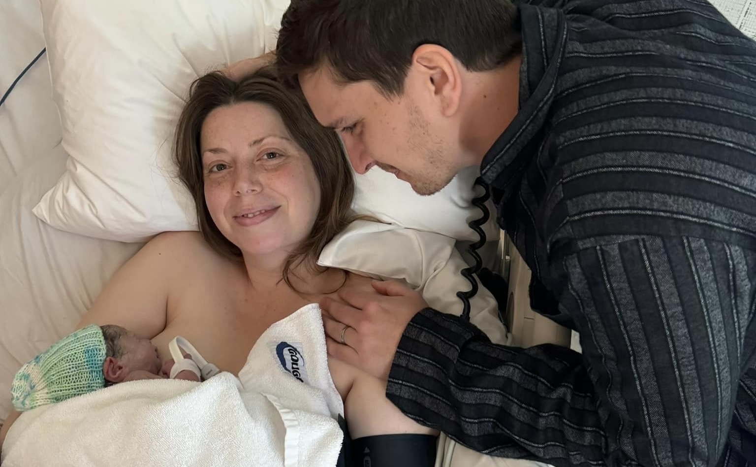 Martha Haylett in a hospital bed, holding a baby in her arms